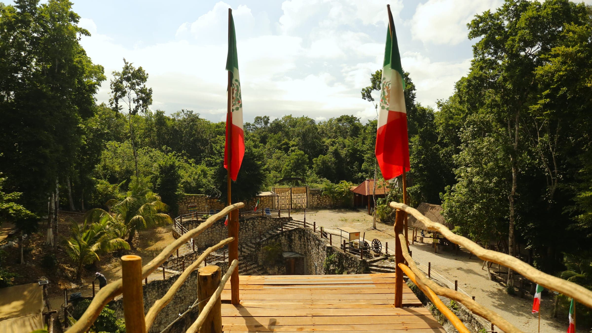 The top of the Jump League jumping tower, flanked by Mexican flags, above the jungle